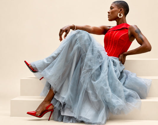 Red sleeveless structured bodice with sheer inset detailing and a full grey tulle skirt
